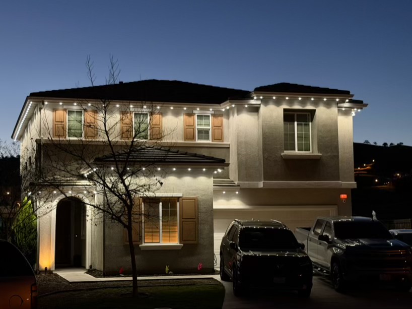 Two-story Central Valley home lit with warm-white permanent roofline lighting